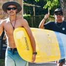 Costa Rica surflessen tijdens vrijwilligerswerk buitenland lopen met een board