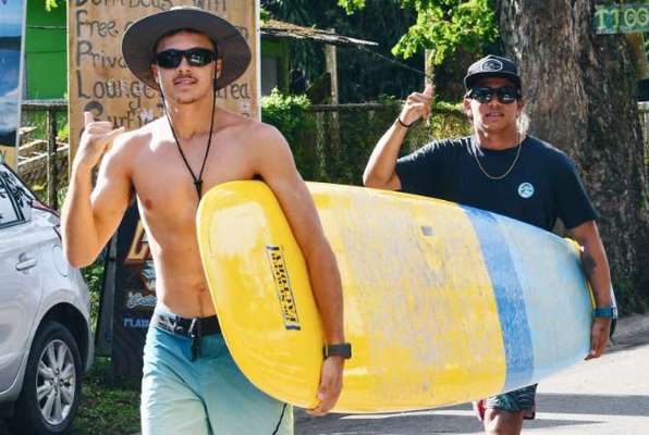 Costa Rica surflessen tijdens vrijwilligerswerk buitenland lopen met een board