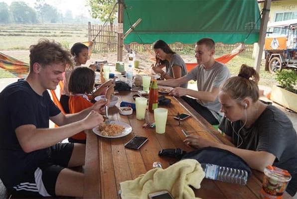 Vrijwilligerswerk Thailand community project vrijwilligers eten met elkaar 