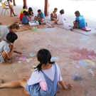 Caroline vrijwilliger Thailand met de kinderen aan het kleuren 